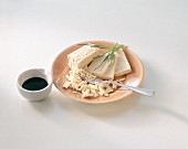 Tofu on plate and a bowl of soya sauce