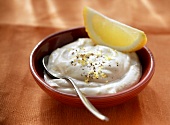 Lemon mayonnaise with lemon wedge in bowl