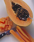 Cutting papaya and spooning out the seeds