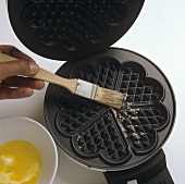 Greasing waffle iron with melted butter