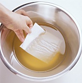 Clarifying stock with kitchen paper (removing fat)