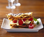 Filo pastry with raspberries and mousse on brown table