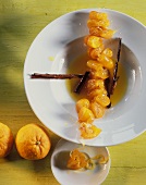 Kumquat chain with cinnamon sticks in orange sauce