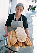 Dorfbäckerin mit frischen Broten in Capileira, Andalusien