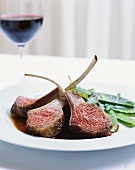 Lamb cutlets with mangetouts; red wine glass
