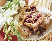 Pieces of Morello cherry cake with icing sugar; white flowers