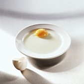 Altes aufgeschlagenes Ei auf weißem Teller