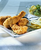 Fried chicken with lemon and potato and cucumber salad