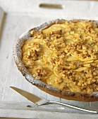 Apple tart with crumble and pine nuts on tray