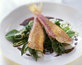 Red mullet on spinach in red wine with onions
