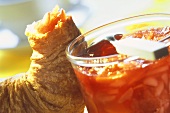Peach and strawberry jam with slivered almonds; croissant