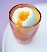 Egg in glass on white plate
