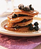 Pancakes with berries, icing sugar and maple syrup