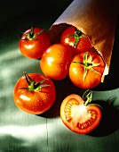 Tomatoes with drops of water, some in paper bag
