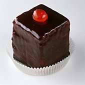 Petit four with chocolate icing and cherry