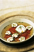 Carpaccio soup with poached egg and mushrooms