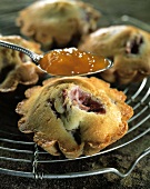 Plum muffins with apricot jam on cake rack