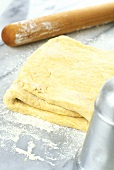 Folded puff pastry, rolling pin, sugar sifter