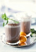 Hot orange and mint cocoa in glasses on tray