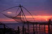 Fishing nets by the sea against the sunset