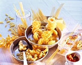 Lots of different types of pasta in dishes; tomato sauce