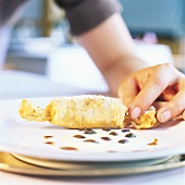 Hand holding deep-fried crepe roll