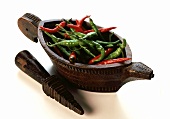 Chili peppers in carved wooden bowl
