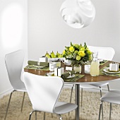 Gedeckter Tisch in Grün und Weiß mit weissen Stühlen
