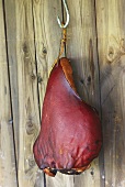 Westphalian ham on hook on wooden wall
