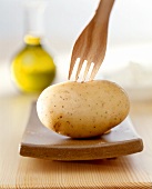 Potato with wooden fork and olive oil