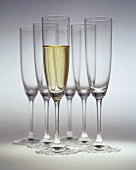 Glass of champagne in front of empty champagne glasses