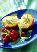 Baked peaches with flaked almonds and berries