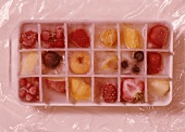 Ice cubes with frozen fruit in ice cube container