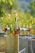 Rosewein in Gläsern und Flasche auf Tisch (Provence)