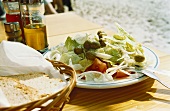 Greek salad with farmhouse bread on table in open air