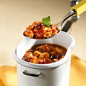 Chili chicken on spoon and in storage container