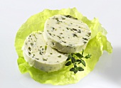 Two slices of herb butter on lettuce leaf