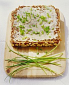 Bread and butter with chives on chopping board