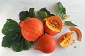Orange Hokkaido pumpkins, one with piece cut off