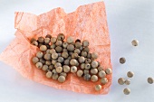 White peppercorns on pink paper
