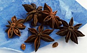 Several star anise on blue paper