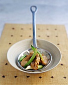 Roast pork with spring onions on ladle