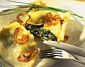 Spinach-filled pasta envelopes with onions