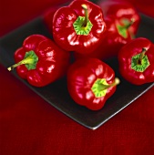 Red peppers on black plate