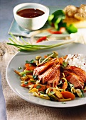 Sweet and sour duck breast with vegetables and rice; soy sauce