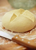 Unbaked bread on chopping board