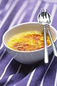 Crème brulee in bowl with cutlery