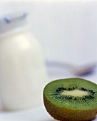 Halbe Kiwi und Glas Joghurt