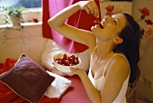 Young woman eating red cherries