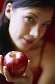 Junge Frau hält roten Apfel